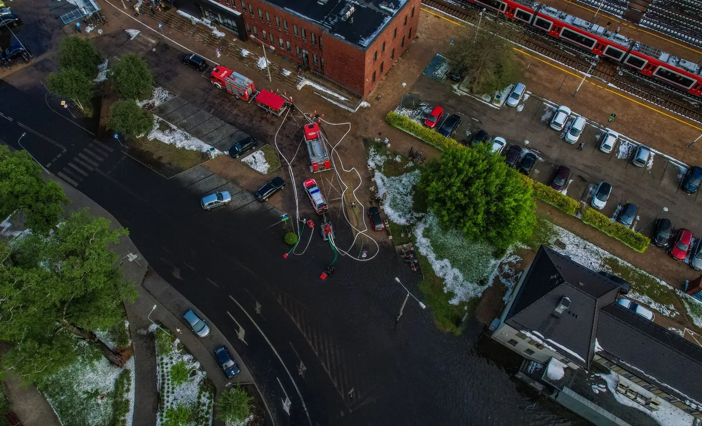Overstroomde straat met hulpdiensten tijdens hoogwater